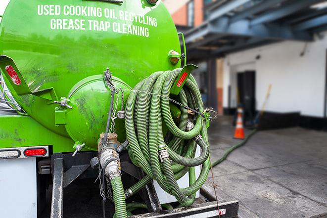 a grease trap being pumped by a sanitation technician in Sewall's Point, FL